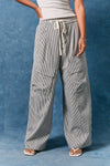Person wearing gray striped cargo pants against a blue background